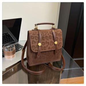 Détail d'un sac à main léopard marron sur un bureau en verre dans un bureau chic