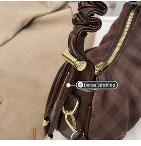 Close-up of fine stitching and gold zipper detail on a brown checkered tote bag