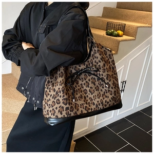Fashionable leopard print tote bag worn on shoulder showing large capacity and bow detail
