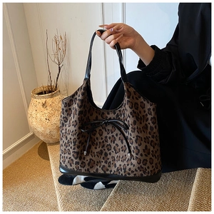 Detailed view of leopard print tote bag with black leather bow and stylish trim