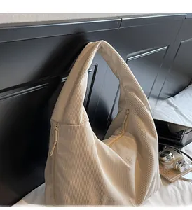 Détail d'un sac fourre-tout en velours côtelé beige avec poignées et fermeture éclair