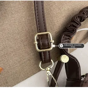 Detail of dark brown leather shoulder strap with golden adjustable buckle and pleated handle