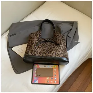 Detailed top view of leopard print tote bag with black bow on a minimalist lifestyle background