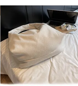 Détail de la texture d'un sac cabas en velours côtelé écru avec large bandoulière