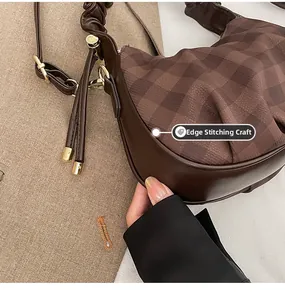 Detailed macro view showing the precise piping craft on the brown plaid pleated handbag