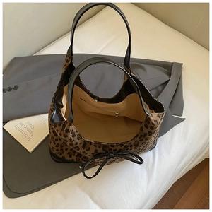 Close-up of leopard print tote bag showing internal zipper pocket and beige lining