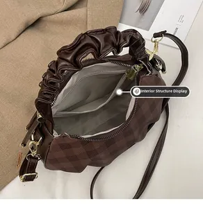 Interior details of deep brown checkered crossbody bag with plaid lining and zip pocket