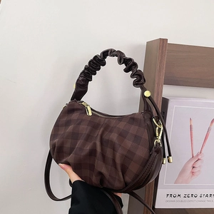 Detail of dark brown checkered cloud bag with ruched handle and gold zipper hardware