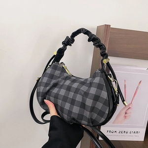 Detail of checkered crescent bag with black cloud pleated handle and gold hardware