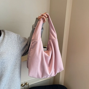 Gros plan du sac hobo en maille côtelée rose montrant sa texture et sa fermeture éclair