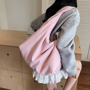Texture détaillée du sac à bandoulière en velours côtelé rose avec rayures verticales