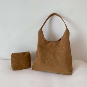 Brown suede hobo tote bag set with matching pouch in minimalist indoor setting