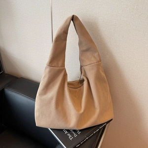 Vue détaillée de la texture du tissu en velours côtelé marron clair du sac hobo minimaliste