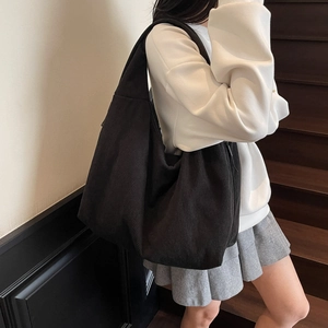 Détail de la texture d'un sac bandoulière en velours côtelé noir au tissu nervuré