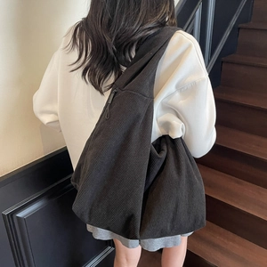 Détail du tissu en velours côtelé noir du sac hobo montrant sa texture et sa grande taille