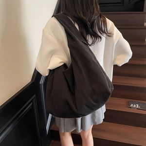 Détail d'un grand sac bandoulière en velours côtelé noir avec des rayures verticales chic