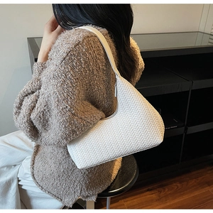Dettaglio della borsa hobo bianca intrecciata con trama raffinata e tracolla in pelle