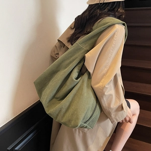 Détail de la texture en velours côtelé vert sur le grand sac à bandoulière demi-lune