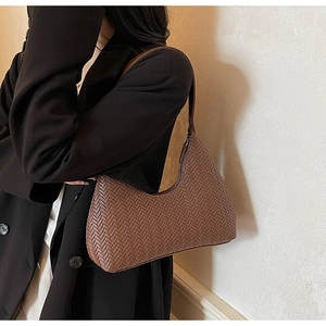 Vue détaillée du sac porté épaule marron tressé, design élégant en cuir pour femme.