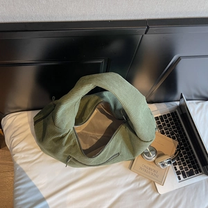 Vue détaillée d'un sac cabas en velours côtelé vert avec texture côtelée et fermeture