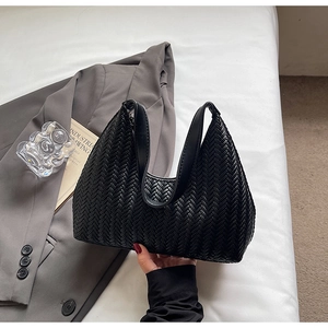 Dettaglio della borsa hobo nera con trama intrecciata a V e tracolla liscia