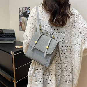 Sac à main carré gris vintage en similicuir avec boucles dorées porté par un modèle