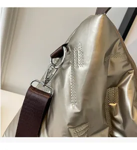 Détail du sac matelassé doré champagne avec texture métallique et crochet argenté poli