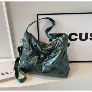 Détail du sac matelassé vert foncé avec finition métallique et large bandoulière