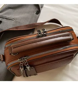 Detailed close-up of premium dark brown leather crossbody bag with dual metal zippers