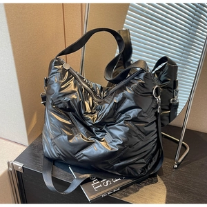 Gros plan sur le sac bandoulière noir matelassé avec texture tissée et détails argentés