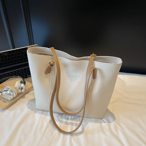 Grand sac cabas beige avec anses brunes et ordinateur sur un bureau de travail