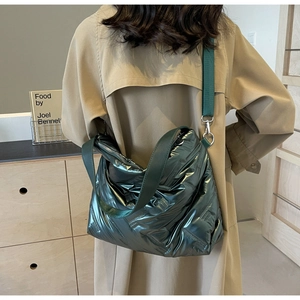 Détail du sac matelassé vert foncé avec finition métallique et large bandoulière réglable