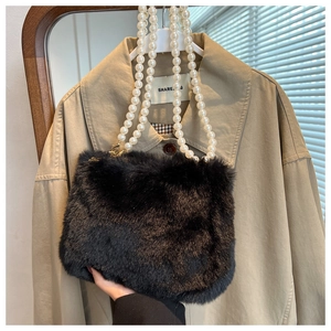 Detail of plush black faux fur handbag featuring double-row white pearl chain strap