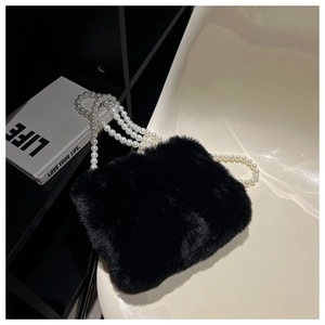 Detail of black faux fur shoulder bag featuring elegant large white pearl chain strap
