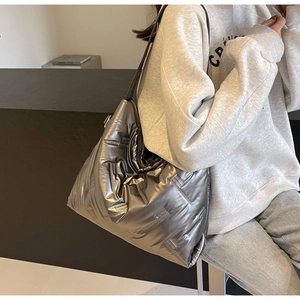 Détail du sac cabas matelassé argenté brillant avec texture rembourrée moderne et chic