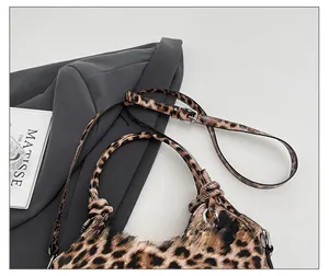 Detail of adjustable leopard print bag strap with silver metal buckle and knotted handle