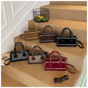 Detail of mini square handbags in vintage colors and textures with top handles and straps