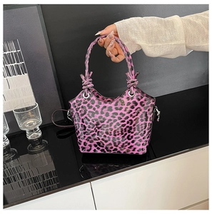 Détail du sac léopard rose avec poignée nouée et œillets métalliques argentés
