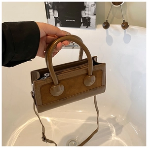 Detail of vintage brown shoulder bag with suede and leather textures in a lifestyle setting