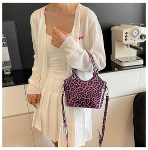 Purple leopard print crossbody bag styled with white outfit in minimalist setting