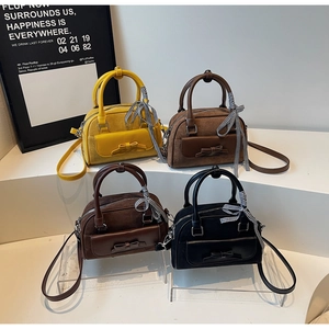 Detalle de bolsos bandolera de ante en cuatro colores con lazos y cintas de cuadros