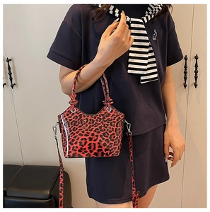 Close-up of red leopard print bucket bag with glossy finish and silver metal hardware