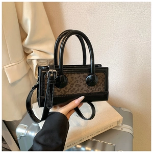Detail of trendy crossbody bag with leopard print stitching on premium black leather