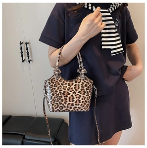 Detail of leopard print bucket bag with knotted handle and glossy synthetic leather texture