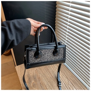 Macro view of black leather bag with leopard pattern texture and metal zipper detail