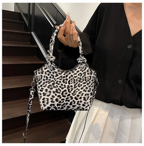 Detail of trendy leopard print bucket bag with wave edge design and silver hardware