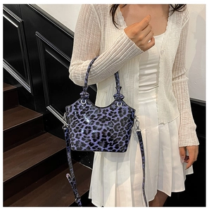 Détail du sac violet à motif léopard avec poignée en anneau argenté et fini brillant