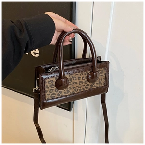 Close-up of vintage brown leopard print handbag with leather straps and silver zipper