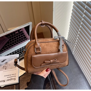 Détail d'un sac bandoulière vintage marron avec texture en daim et ruban à carreaux sur l'anse