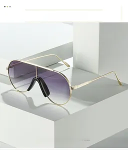 Close-up of golden metal pilot sunglasses with purple gradient lenses on white stone